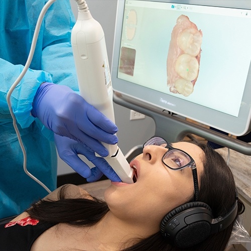 Dental patient having her teeth digitally scanned