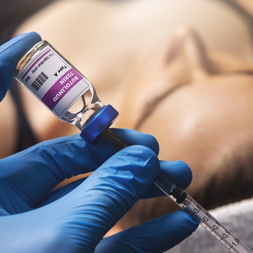 a dentist holding a vial of wrinkle treatment 