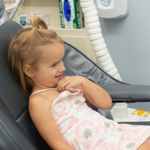 Little girl leaning back in dental chair