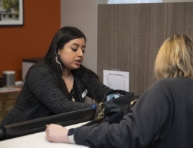 Dental team member talking to woman at front desk