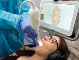 Dental patient having her teeth scanned by her emergency dentist