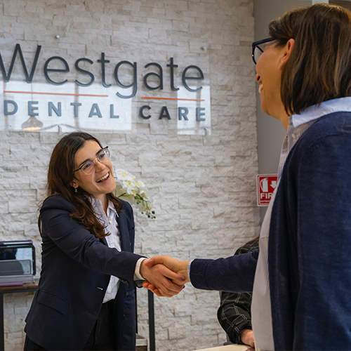 Dental team member shaking hands with a patient