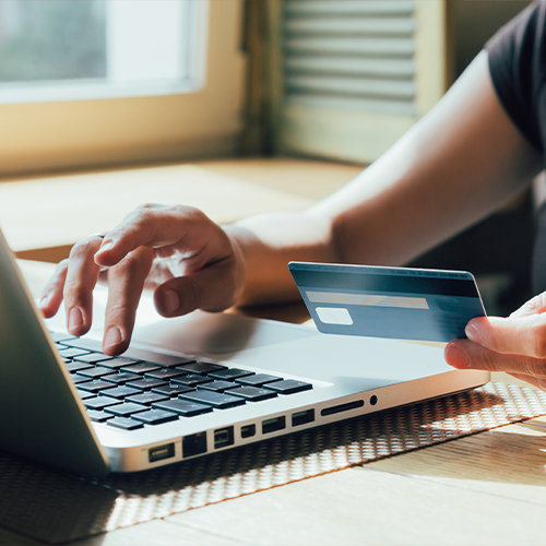 Person typing their credit card information on a laptop