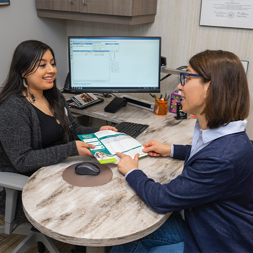 Dental team member handing a pamphlet to a patient