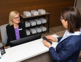 Woman holding her phone while talking to dental office receptionist