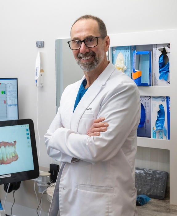 Doctor Kics smiling in white lab coat in dental treatment room