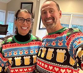 Doctor Kics and his wife wearing holiday sweaters