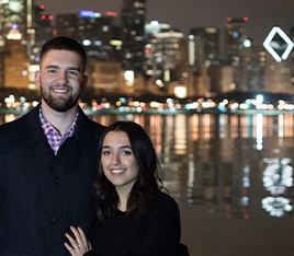 Doctor Kufo smiling with his wife with nighttime city lights in background