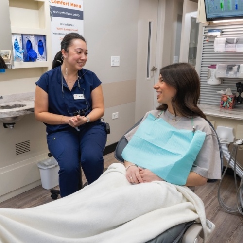 Young woman talking to her dentist about tooth colored fillings in Arlington Heights