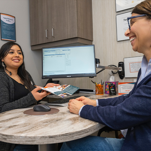 Dental team member showing a pamphlet to a patient